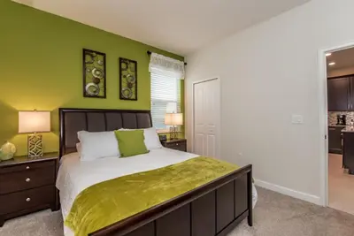 a bedroom with a bed and a green wall at Enchanting Escape Private Pool SPA Games Room in Orlando