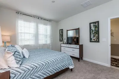a bedroom with a bed and a dresser with a mirror at Enchanting Escape Private Pool SPA Games Room in Orlando