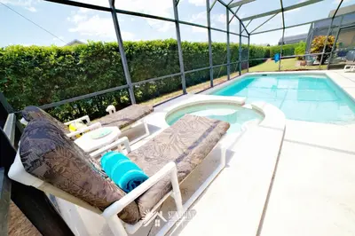 a swimming pool with a chaise lounger next to a swimming pool at Affordable Luxury Home Near Walt Disney World - Sunshine Villa at Glenbrook Resort, Orlando, Florida in Orlando