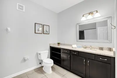 a bathroom with a toilet and a sink and a mirror at Ground-Floor Vista Cay Condo Near Clubhouse Pool in Orlando