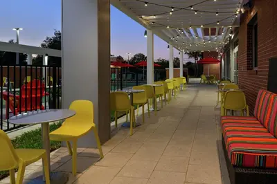 a row of tables and chairs on a patio at Home2 Suites By Hilton Orlando Near UCF in Orlando
