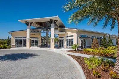 a large building with a palm tree in front of it at 3830 Premier Villa 6Bd Private Pool and Game Room in Kissimmee