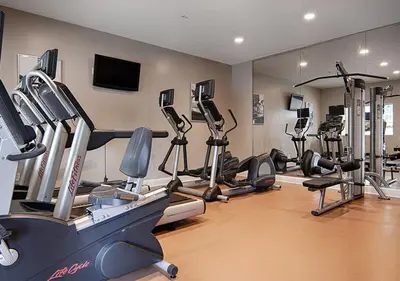 a gym with a bunch of treadmills and machines at The Point Hotel & Suites - 705S Luxury - Pool view - Close to Universal in Orlando