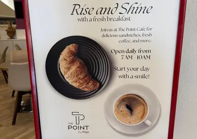 a sign with a cup of coffee and a pastry at The Point Hotel & Suites - 705S Luxury - Pool view - Close to Universal in Orlando