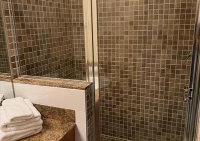 a bathroom with a shower and a sink with towels at The Point Hotel & Suites - 503 Luxury - Pool view - Close to Universal in Orlando