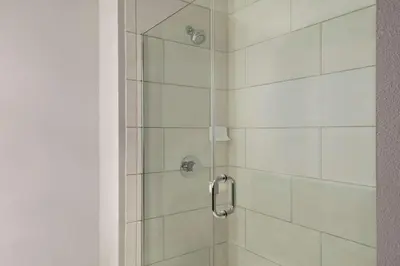 a shower stall with a glass door with a shower at La Quinta Inn & Suites by Wyndham Orlando I-Drive Theme Parks in Orlando
