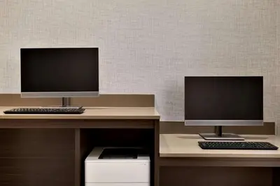 two computer monitors sitting on top of a desk at La Quinta Inn & Suites by Wyndham Orlando I-Drive Theme Parks in Orlando