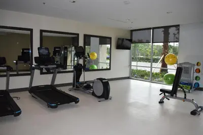 a room with a gym with several elliptical machines and windows at La Quinta Inn & Suites by Wyndham Orlando I-Drive Theme Parks in Orlando