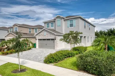 a large white house with a driveway at Precious Home Near Disney With Private Pool, Theater Room And Waterpark & Resort Access At Encore Resort Reunion - 7449Mr in Kissimmee