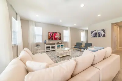 a living room with a large white couch in a room at Precious Home Near Disney With Private Pool, Theater Room And Waterpark & Resort Access At Encore Resort Reunion - 7449Mr in Kissimmee