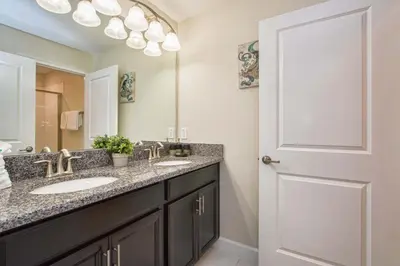 a bathroom with two sinks and a mirror at I - New 4 Bedroom Home - 5 Miles to Disney - Free Water Park - Private Pool in Kissimmee