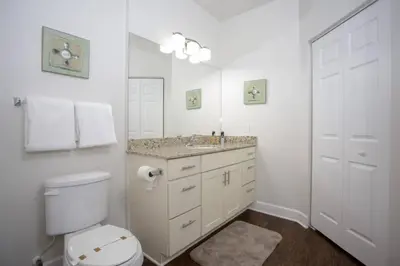 a white bathroom with a toilet and a sink at 2956 Lucaya Village - Gorgeous Four Bed Condo Close to Disney Area in Kissimmee