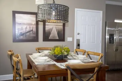 a dining room table with chairs and a chandelier at 2956 Lucaya Village - Gorgeous Four Bed Condo Close to Disney Area in Kissimmee