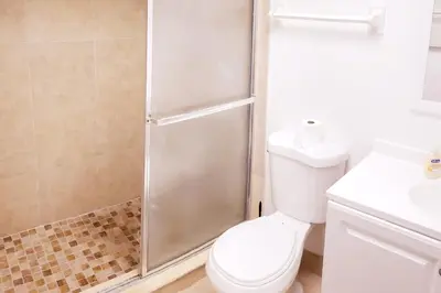 a bathroom with a shower with a toilet and a sink at D4 Large Private Master Room & Bath with 55