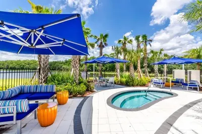 a patio with blue umbrellas and a swimming pool at 3840 Supreme Villa 6Bd Private Pool and Game Room in Kissimmee