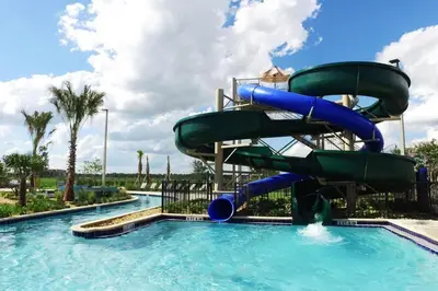 a water slide in a pool at a resort at Wonderful 5 Bedroom w/ Pool Close to Disney 4801 in Kissimmee