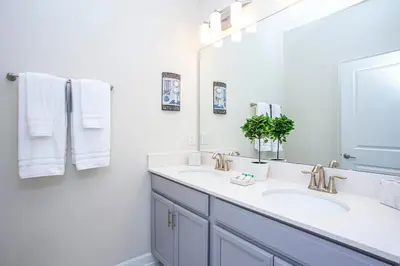 a bathroom with two sinks and a large mirror at Wonderful 5 Bedroom w/ Pool Close to Disney 4801 in Kissimmee