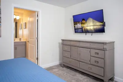 a bedroom with a bed and a dresser with a mirror at Wonderful 5 Bedroom w/ Pool Close to Disney 4801 in Kissimmee
