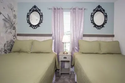 two beds in a room with two mirrors on the wall at Wonderful 5 Bedroom w/ Pool Close to Disney 4801 in Kissimmee
