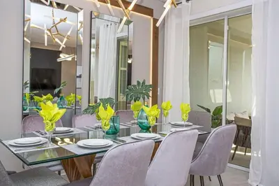 a dining room with a table with chairs and yellow flowers at Gorgeous 4 Bedroom w/ Pool Close to Disney 4836 in Kissimmee