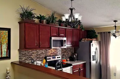 a kitchen with red cabinets with potted plants on top at B2 Private Room With 55