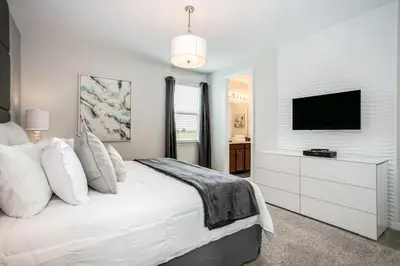 a white bedroom with a bed and a tv at Jedi Temple! Take A Virtual Tour Private Pool! Villa in Orlando