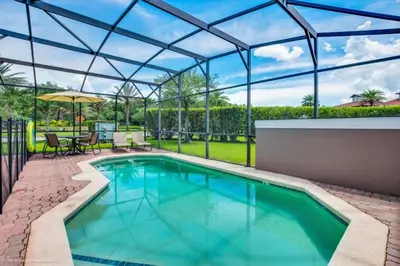a swimming pool with a glass roof and a patio at Bella Vidatown Home With Full Size Pool! Townhouse in Kissimmee