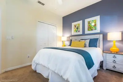 a bedroom with a large bed with a blue wall at Bella Vidatown Home With Full Size Pool! Townhouse in Kissimmee