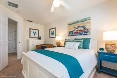 a bedroom with a white bed and a blue nightstand at Bella Vidatown Home With Full Size Pool! Townhouse in Kissimmee