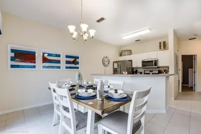 a dining room and kitchen with a table and chairs at Bella Vidatown Home With Full Size Pool! Townhouse in Kissimmee