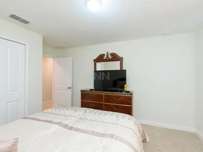 a bedroom with a bed and a tv on a dresser at Storey Lake - Private Pool Home 10 Min to Disney in Kissimmee