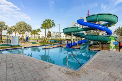 a water slide in a park with a swimming pool at Storey Lake - Private Pool Home 10 Min to Disney in Kissimmee