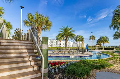 a resort pool with stairs and palm trees at Storey Lake - Private Pool Home 10 Min to Disney in Kissimmee