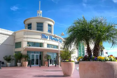 a hotel building with palm trees in front of it at The Florida Hotel & Conference Center in the Florida Mall in Orlando