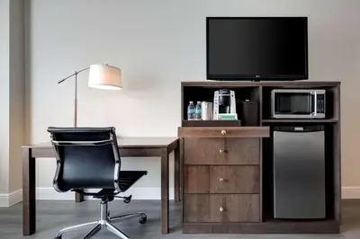 a desk with a chair and a tv and a computer at The Florida Hotel & Conference Center in the Florida Mall in Orlando