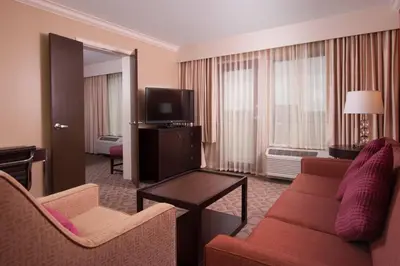 a living room with a couch and a tv at Delta Hotels by Marriott Orlando Lake Buena Vista in Orlando