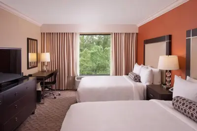 a hotel room with two beds and a desk and a television at Delta Hotels by Marriott Orlando Lake Buena Vista in Orlando
