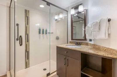 a bathroom with a shower and a sink and a mirror at Hilton Vacation Club Aqua Sol Orlando West in Orlando