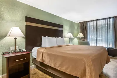 a hotel room with a bed and a desk with a phone at Clarion Inn Orlando International Drive - ICON Park in Orlando