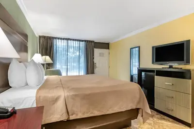 a hotel room with a bed and a flat screen tv at Clarion Inn Orlando International Drive - ICON Park in Orlando