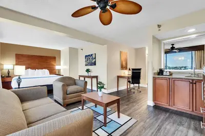 a hotel room with a bed and a living room at Best Western Orlando Gateway Hotel in Orlando
