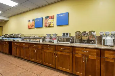 a buffet line in a cafeteria with food on it at The Adventure Hotel by the Parks in Orlando