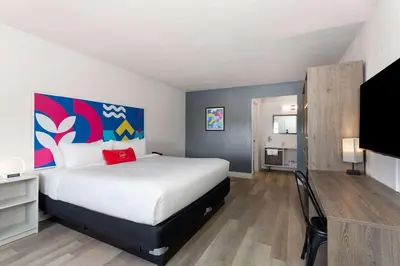 a bedroom with a large bed and a tv at Howard Johnson by Wyndham Orlando Lake Buena Vista South in Kissimmee