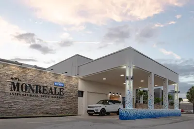a car dealership with a white car parked in it at Hotel Monreale Express International Drive Orlando in Orlando