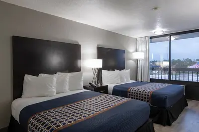 a hotel room with two beds and a balcony at Hotel Monreale Express International Drive Orlando in Orlando