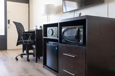 an office with a microwave and a desk with a chair at Hotel Monreale Express International Drive Orlando in Orlando