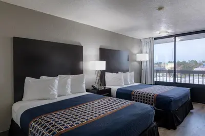 a hotel room with two beds and a balcony at Hotel Monreale Express International Drive Orlando in Orlando