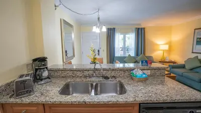 a kitchen with a sink and a living room at Blue Tree Resort at Lake Buena Vista in Orlando