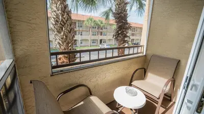 a balcony with chairs and a table and a window at Blue Tree Resort at Lake Buena Vista in Orlando