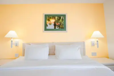 a bedroom with a white bed with two lamps at Berkley Lake Townhomes in Kissimmee